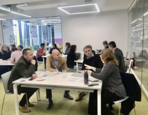A picture of a workshop with several people collaborating around a desk